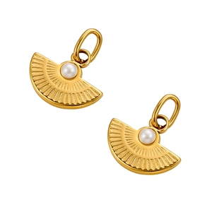 Detail of fan-shaped golden pendant featuring radial engravings and an elegant white pearl