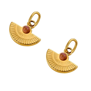 Macro detail of vintage fan-shaped golden pendants with purple gemstone and radial texture