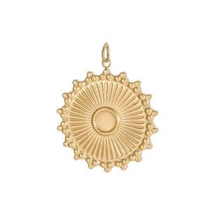 Macro detail of a golden sunburst round pendant with vintage radial texture and bead edge