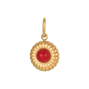 Macro shot of gold sunburst pendant featuring a vibrant red stone inlay and ribbed texture