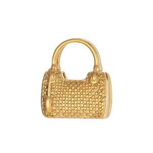 Macro detail of a gold handbag-shaped pendant with dense beaded textures and tiny tag