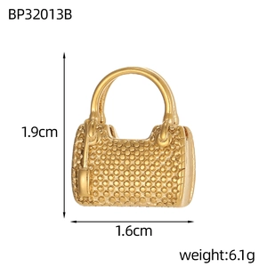 Detail showing small golden bag pendant dimensions 1.9cm by 1.6cm with dotted texture