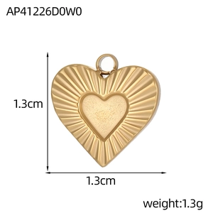 Détail d'un pendentif coeur doré avec rayures radiales et un centre de texture mate