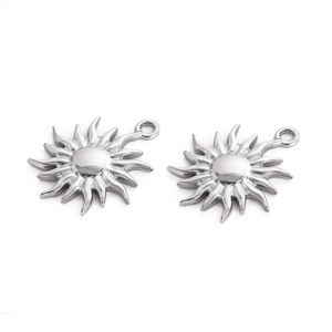 Close-up of two sun-shaped silver stainless steel pendants with wavy radiant lines