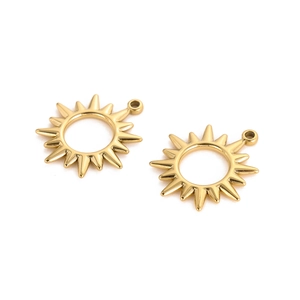 Detail of two golden sunburst charms with a hollow center for jewelry making