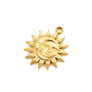Detailed view of a polished gold celestial sun face pendant with rays and a bail