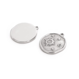 Macro detail of silver sun and moon pendants with handcrafted edges for DIY jewelry making