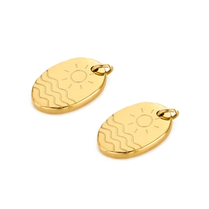 Close-up of gold-plated oval pendants featuring sun rays and ocean wave engravings