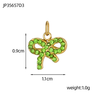 Detail view of a 0.9cm gold-plated bow pendant with green crystals and top hanging loop