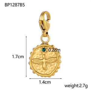 Macro detail of gold coin pendant with embossed bee, blue crystal, and lobster clasp