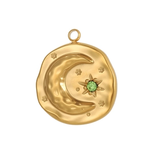 Détail d'un pendentif monnaie doré en acier inoxydable avec lune, étoiles et zircon vert