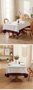 Detail of white linen tablecloth featuring elegant dark red pleated ruffle edge for dining table