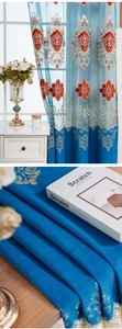 Detail of blue European embroidered curtain with golden floral patterns and sheer lace