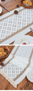 Detail of Nordic table runner featuring hollow diamond patterns and brown lace with tassels