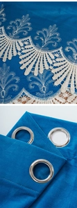 Close-up of blue velvet curtain with silver metal grommets and white lace embroidery
