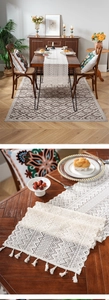 Macro detail of beige crochet lace table runner with geometric patterns and tassel trim
