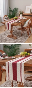 Detail of rustic woven table runner with red stripes and elegant tassels on dark wood