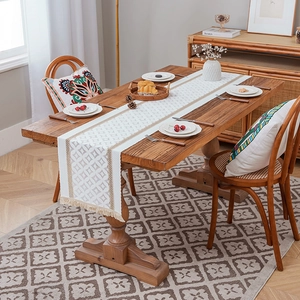 Modern bohemian table runner with beige geometric patterns and elegant fringed edges