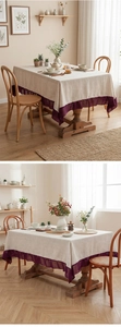 Detail of linen tablecloth with purple chiffon ruffle edges on a rectangular table