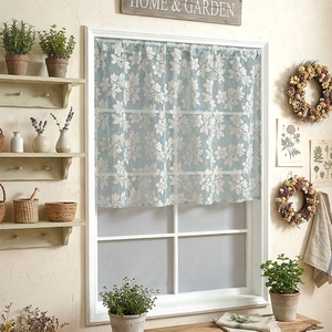 Light blue floral cafe curtain with white flower prints on a classic four-pane window