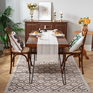 Vintage crochet table runner with tassels on a rustic wooden dining table setting