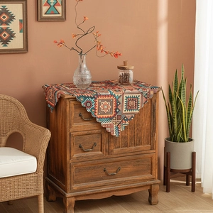 Ethnic bohemian tablecloth with colorful geometric patterns on a wooden table