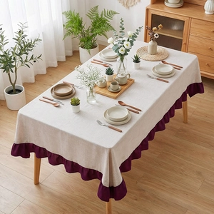 Nordic minimalist rectangle linen tablecloth with purple ruffled edges on a wooden table