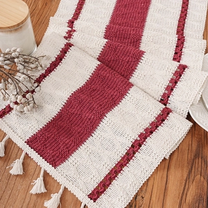 Bohemian striped table runner with tassels on a wooden surface with home decor