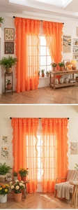 Detail showing vibrant orange semi-transparent curtains with ruffled edges and soft texture