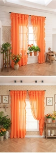 Detail of bright orange semi-transparent voile curtain with ruffled edges and pleated top