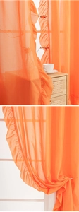 Detail of light orange translucent chiffon curtain with elegant ruffled edges and soft texture