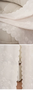 Detailed close-up of floral jacquard lace curtain with elegant wavy scalloped edges