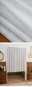 Detailed close-up of white floral lace door curtain with elegant scalloped edges