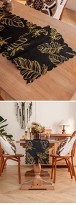 Detail of black table runner with golden feather patterns and wavy scalloped edges