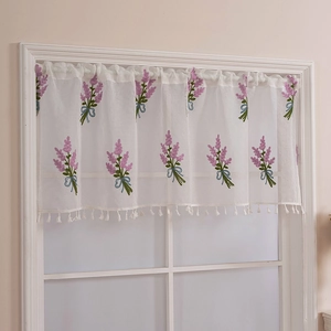 Detail of white lace cafe curtain with lavender embroidery and blue ribbon bows