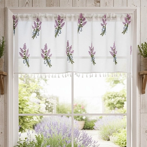 Detail of lavender floral embroidery and white tassels on a sheer lace cafe curtain