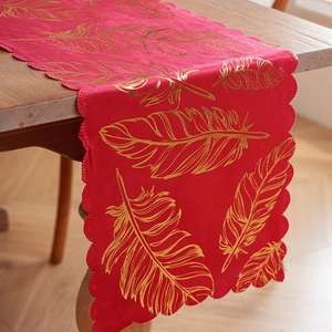 Luxury red velvet table runner with gold feather print and elegant scalloped edges