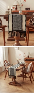 Detail of black and white woven table runner with decorative tassels and boho texture