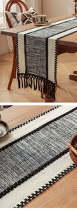 Detail of bohemian black and white woven table runner with thick cotton fringe