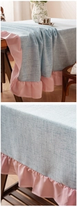 Detail of light blue linen texture tablecloth with pink ruffled chiffon edges