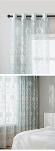 Close-up of light blue sheer curtains with white damascus embroidery and silver grommet top