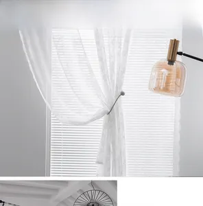 Detail of white lace sheer curtain with fine floral embroidery and linen texture fabric