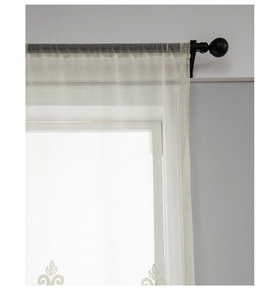 Detail of semi-transparent white sheer curtain with elegant embroidered leaf scroll patterns