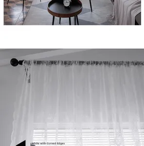 Close-up of white lace curtain featuring floral embroidery and elegant scalloped edges