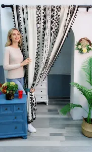 Detail view of Bohemian linen kitchen curtain with black geometric prints and tassels