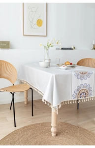 Detail of Nordic grey tablecloth with bohemian sunflower print and ivory tassels
