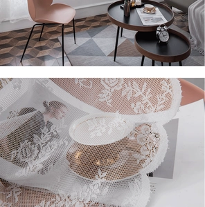 Detailed close-up of white lace curtain featuring intricate rose floral hollow patterns