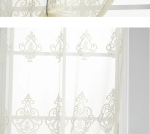 Detail showing white lace embroidery with floral damascus patterns on semi-sheer curtain