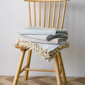 Minimalist Nordic style cotton linen tablecloth with fringe and grid patterns on wooden chair