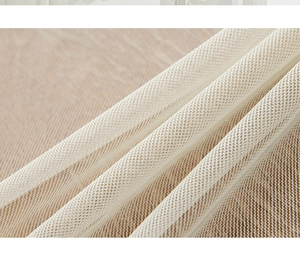 Detailed macro view of semi-transparent white mesh fabric with elegant drape and texture
